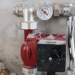 close up view of an industrial plumbing system featuring a pressure gauge and steel pipes